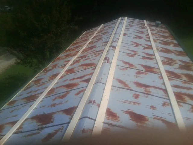 Rusted metal roof panels with new wood purlins before replacement — Storm Damage Roof Repair in Noti by Roofing Brothers